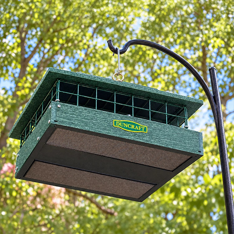 Underside of green Duncraft hanging bird feeder showing the mesh drainage floor and center support.