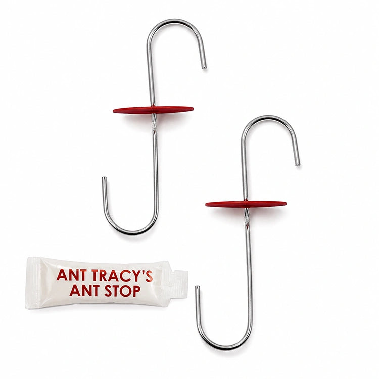 Two metal feeder hooks with red nectar protection disks and a packet of Ant Tracy's Ant Stop ant barrier treatment on a white background.