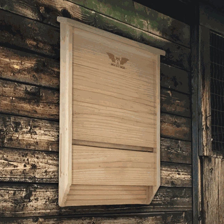 Cedar bat house mounted on the side of a brown barn.