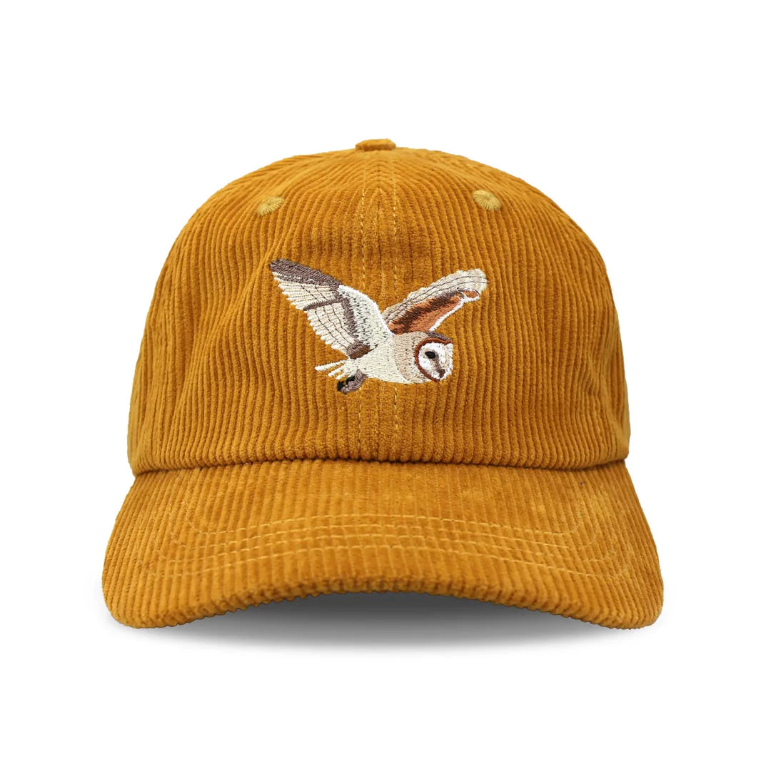 Barn Owl Corduroy Hat, Amber features a mustard-yellow corduroy with an embroidered barn owl in flight, adjustable strap, and unstructured 6-panel crown.
