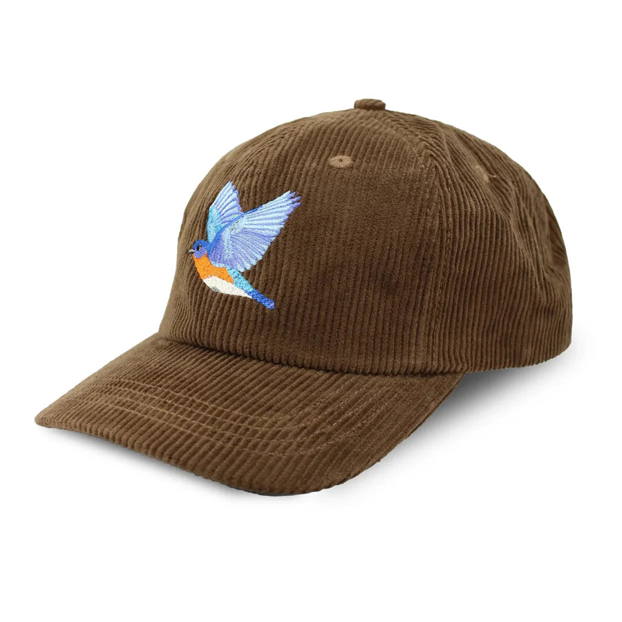 Eastern Bluebird Corduroy Hat, Chestnut: Brown cap with curved brim, featuring a blue and orange embroidered bird, adjustable strap, and tonal eyelets.