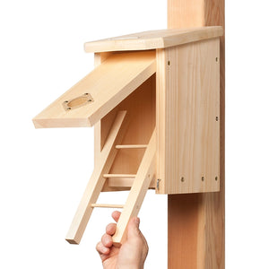 Wooden bird house with hinged front panel and fold-down ladder for easy access, cleaning, and maintenance.