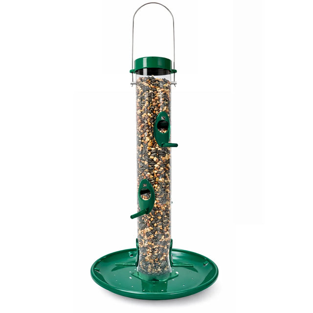 Tube-style bird feeder with a clear seed reservoir, green top and base tray, and multiple feeding ports with perches, filled with mixed seed and shown on a white background.