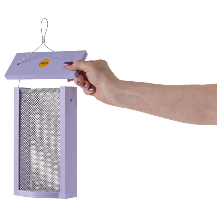 Hand displaying the Tall Finch Feeder, Purple, featuring mesh sides, a flat wooden top, and lavender recycled plastic frame with matching painted nails.