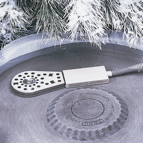 Deluxe Birdbath Heater on a concrete surface. Close-up of stainless steel housing and circular design, ideal for keeping birdbath water ice-free in cold weather.