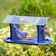 Duncraft Bluebird Cafe Feeder with bluebirds feeding on mealworms, featuring four perches and plexiglass sides to protect food, set in a garden.