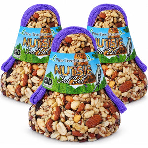 Three Pine Tree Farms Nutsie Seed Bells with blue and green labels and purple hanging loops on a white background.