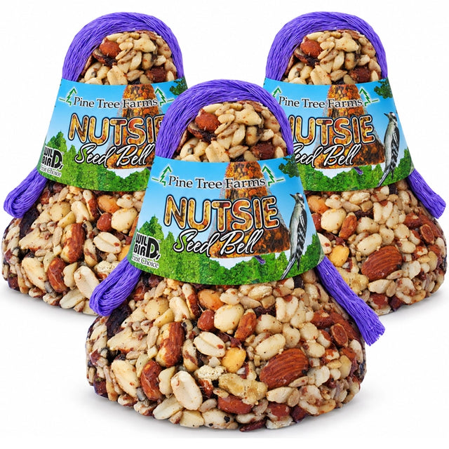 Three Pine Tree Farms Nutsie Seed Bells with blue and green labels and purple hanging loops on a white background.