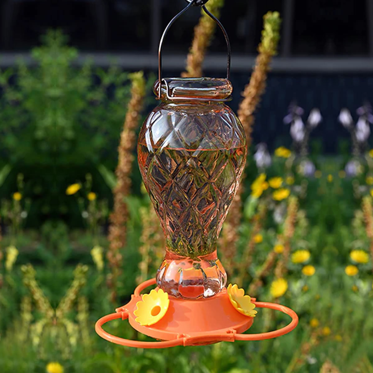 Orange Jewel Glass Oriole Feeder with cut-glass reservoir, metal hanger, orange base, yellow flower feeding ports, and ring perch, perfect for attracting orioles.