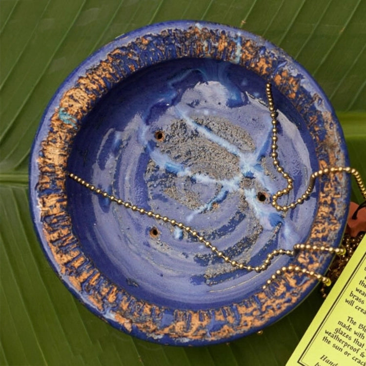 Bluebird Cafe Bird Feeder with a blue bowl showcasing a necklace, designed to attract bluebirds with mealworms. Features easy-to-clean glass dishes for birdwatching.