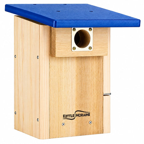 A wooden birdhouse with a light natural wood body and a blue metal roof, featuring a metal entrance hole and the Kettle Moran brand name on the front.