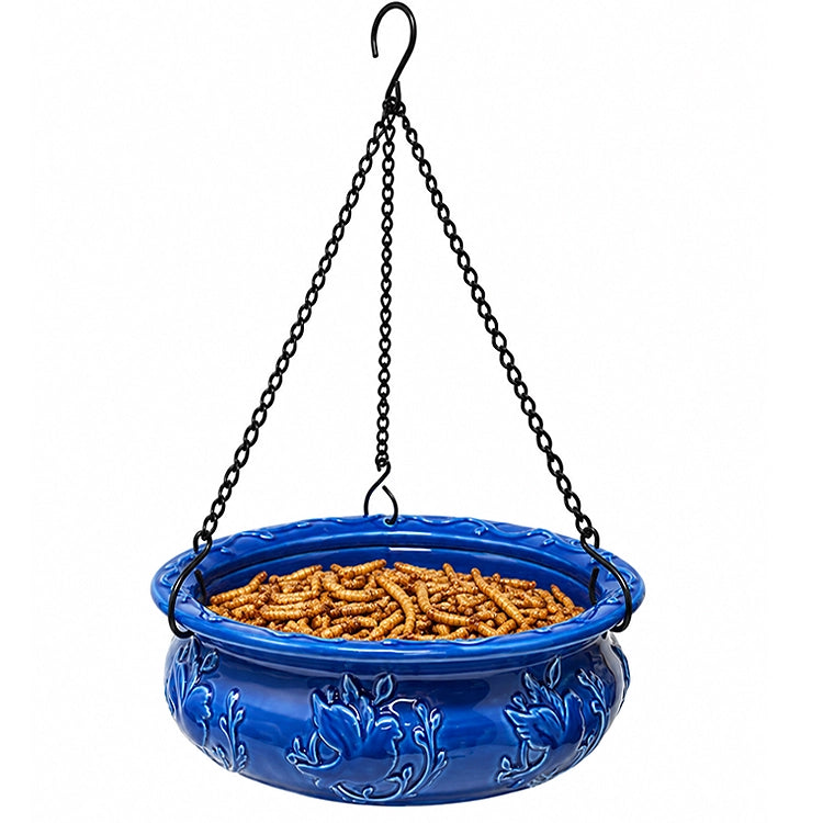 Blue ceramic hanging bird feeder filled with dried mealworms to attract bluebirds, chickadees, wrens, and other insect-eating backyard birds.