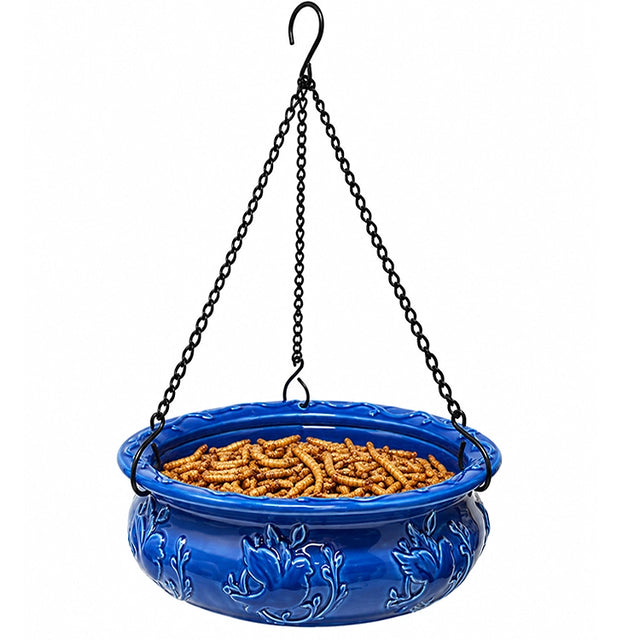 Blue ceramic hanging bird feeder filled with dried mealworms to attract bluebirds, chickadees, wrens, and other insect-eating backyard birds.
