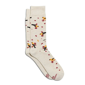 A pair of cream-colored crew socks featuring a pattern of yellow birds, red leaves, and black silhouettes, with 'SAS' and 'SOCKS' printed in red on the toe.