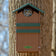 Duncraft Screech/Saw-Whet Owl Nesting Box on tree, owl peeking out. Durable, recycled plastic with ventilation, drainage, and ladder for easy owl access.