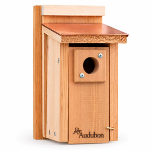 Cedar bluebird house with a copper roof, round entrance, and wooden predator guard on a white background.