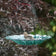 Turquoise handblown recycled glass hanging bird bath with dahlia-inspired floral design suspended from decorative metal chain.
