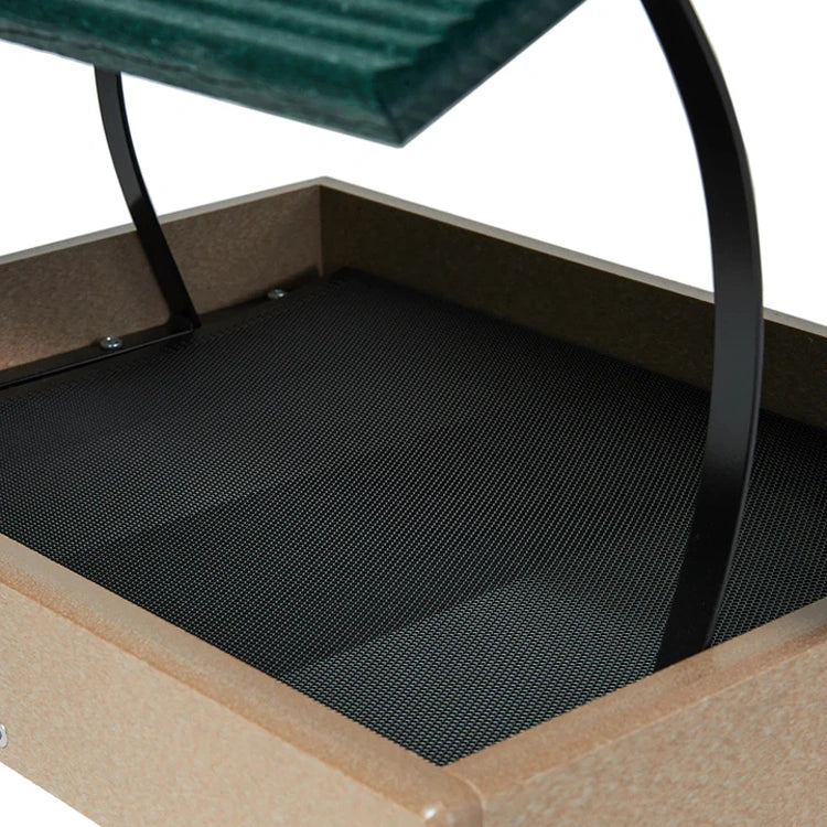 Close-up of a platform bird feeder with a mesh floor and metal frame.