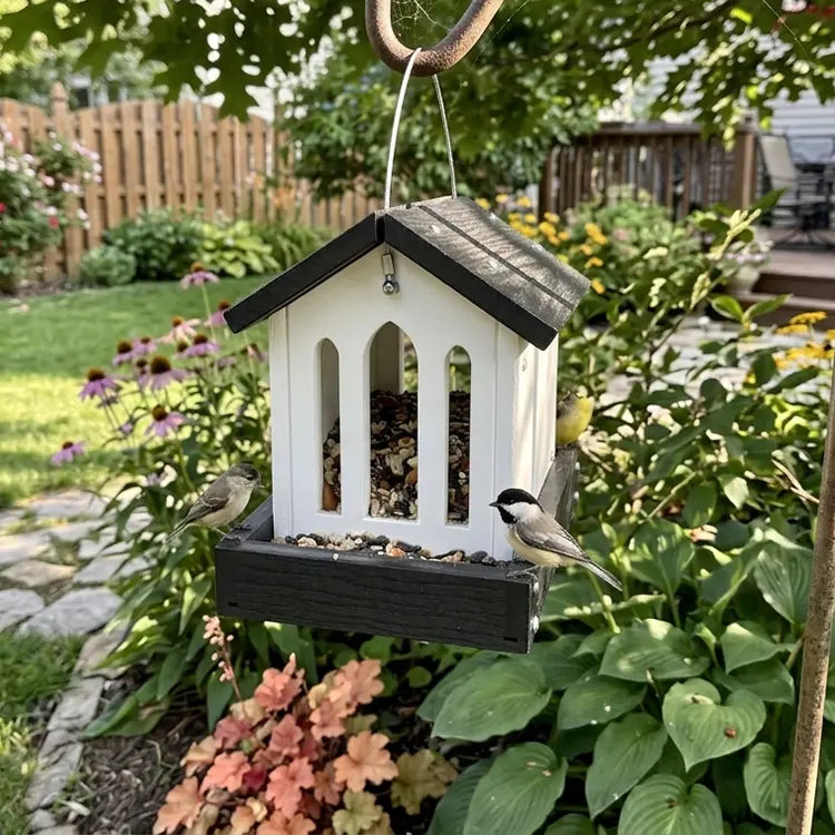 Bird feeder with birds perched on it in a garden setting